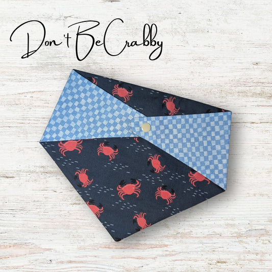 Reversible pet bandana with crab pattern on a wooden surface, featuring the text 'Don't Be Crabby'.