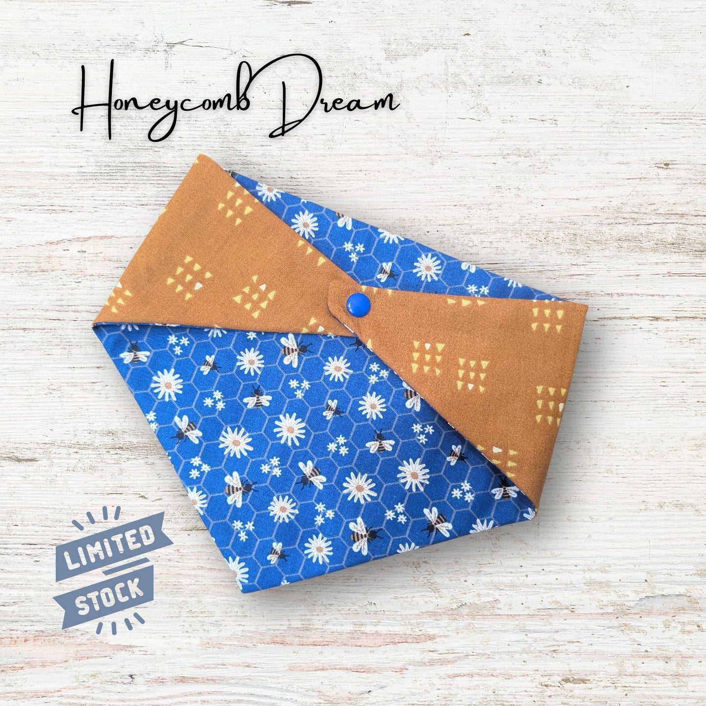 Reversible pet bandana with flowers, honeycomb, and bees, laid out on a wooden surface, featuring 'Honeycomb Dream' branding.
