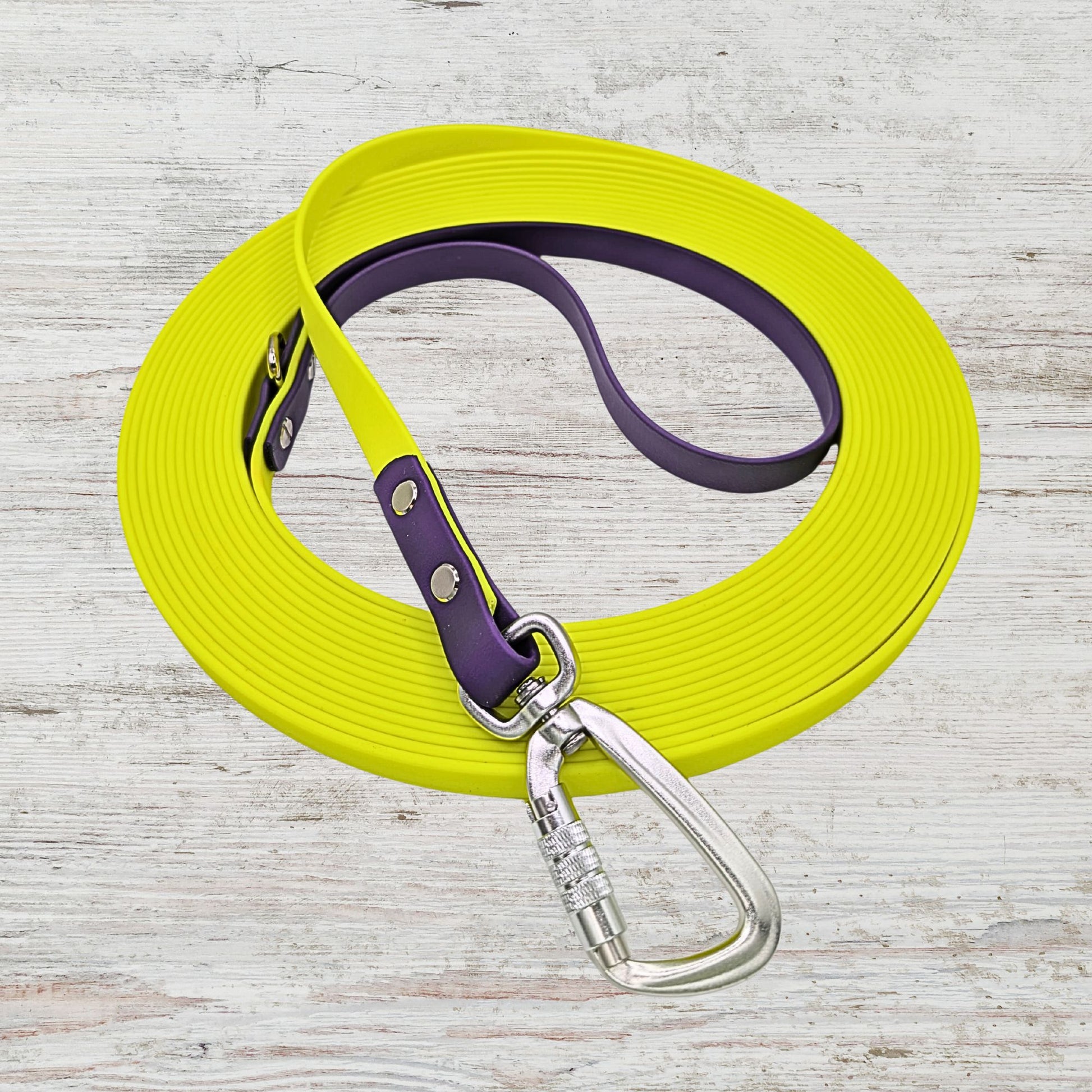 Highlighter yellow long line dog leash with purple handle and silver carabiner.