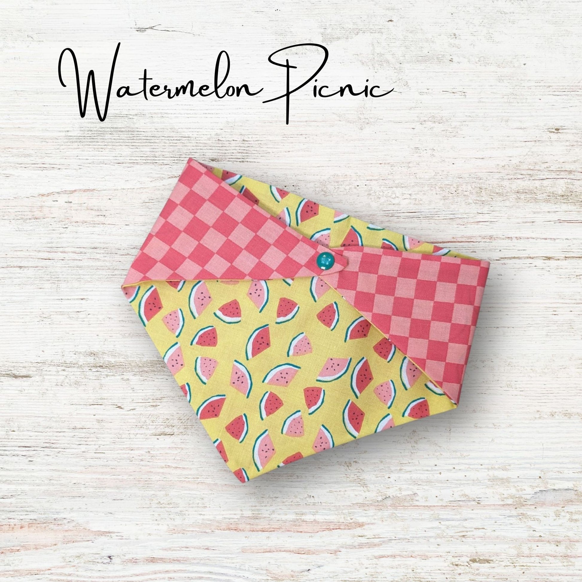 Playful pet bandana featuring a cute watermelon design with a pick chekered print on the everse side