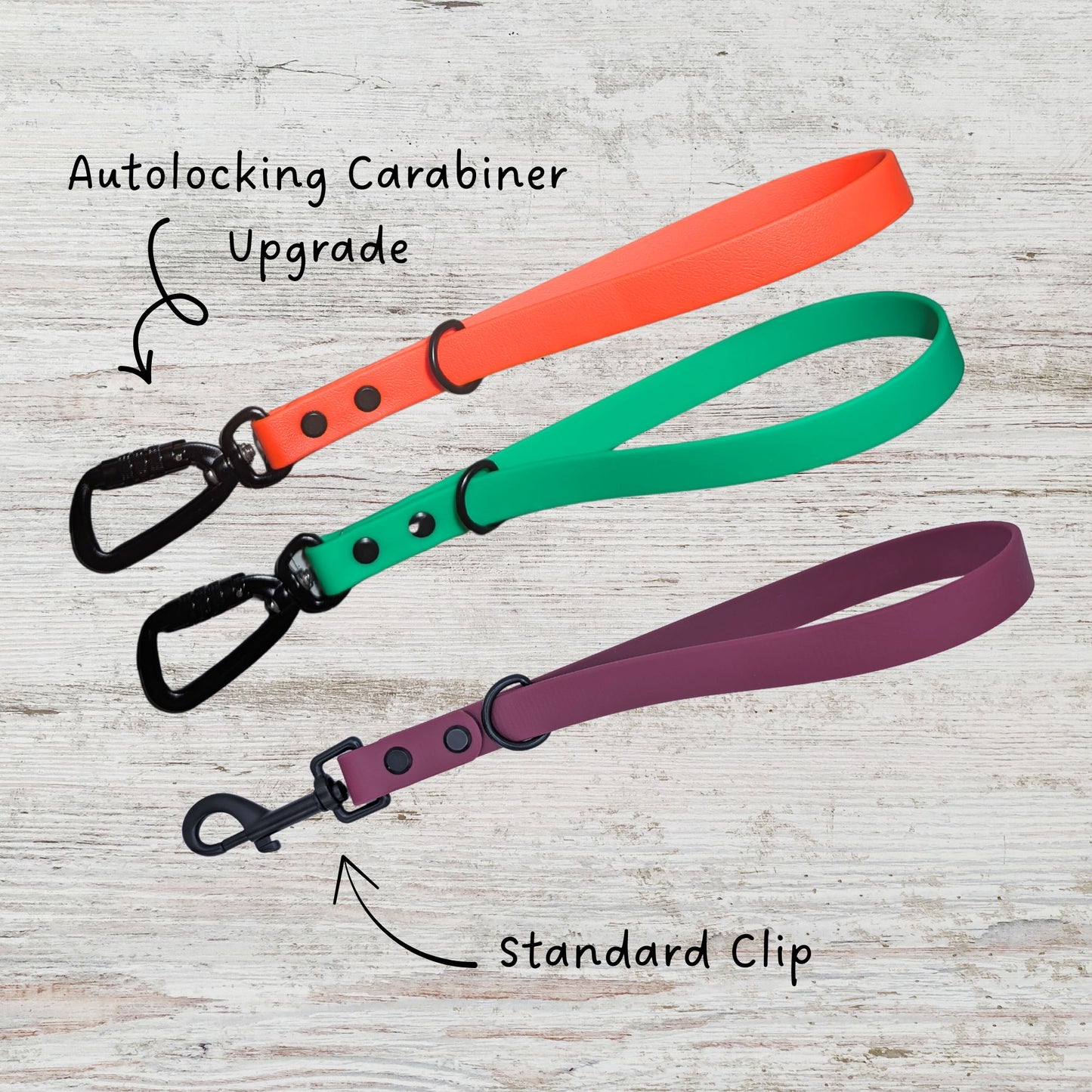 Three dog leash traffic handles in orange, green, and merlot. Two have the autolocking carabiner upgrade and the other has the standard clip.